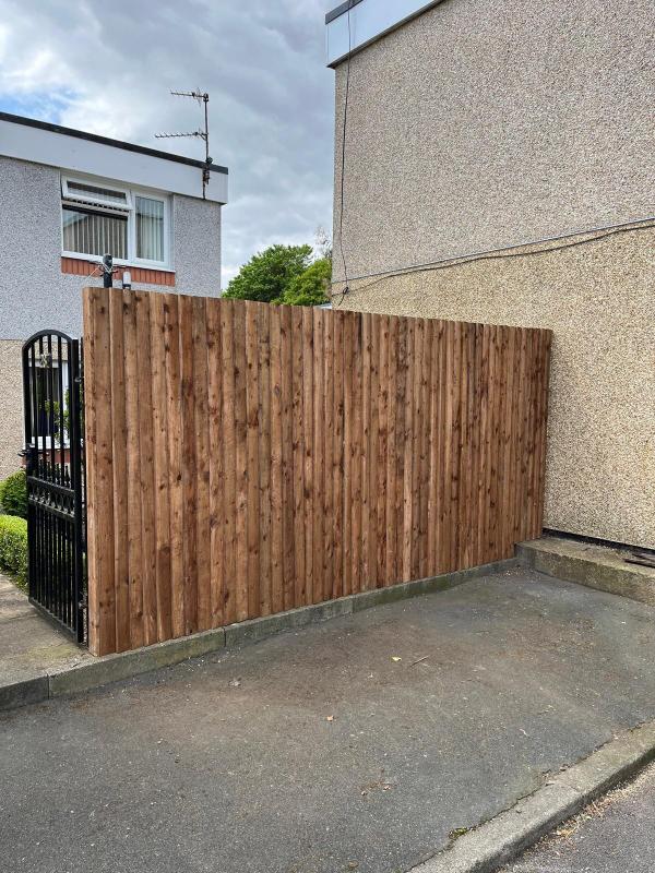 The finished closeboard fence running the full length of the driveway boundary