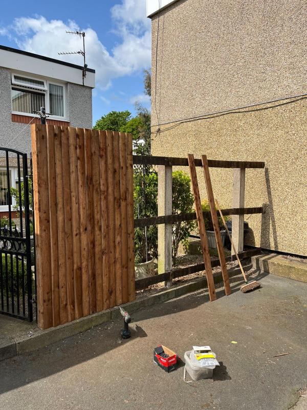 The first section of new closeboard fencing built while the old railings still stand alongside