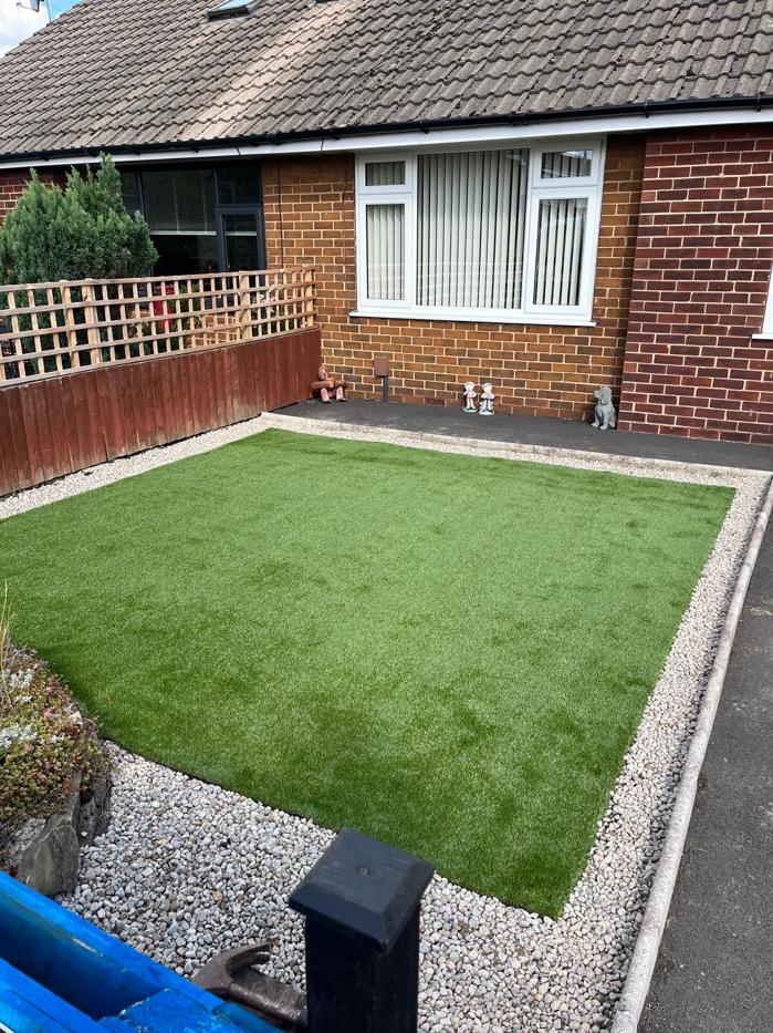 The same front garden finished with a neat artificial lawn and a pale gravel border